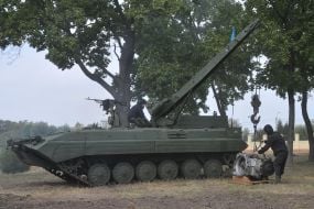 Военнослужащие-танкисты устанавливают двигатель на танк