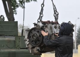 Военнослужащие-танкисты устанавливают двигатель на танк