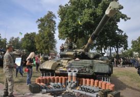 Visitors to the military equipment exhibition inspect the tank