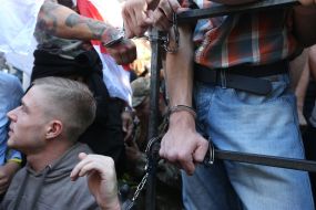 Participants of the action, chained to the fence near the AP
