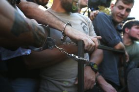 Participants of the action, chained to the fence near the AP