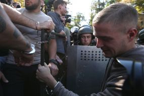 Participants of the action, chained to the fence near the AP