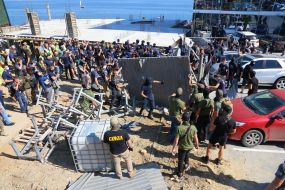 Activists demolish the fence at the construction site