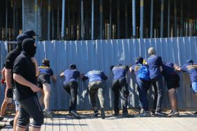 Activists demolish the fence at the construction site