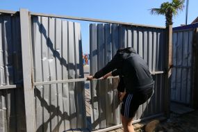 Activists demolish the fence at the construction site