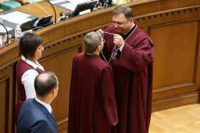 Stanislav Shevchuk passes the judge's breastplate to Irina Zavgorodniy