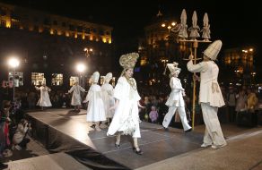 Actors in theatrical costumes on the podium