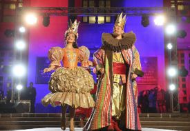 Actors in theatrical costumes of the king and queen on the podium