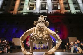 Actor in a theatrical costume of a monkey on a podium