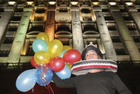 Actor in a theatrical costume with balloons against the background of the KSCA