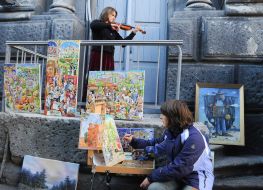 A woman photographs a poster on the building of the Young Theater