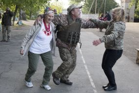 A volunteers dances with a military officer