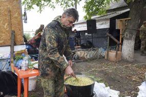 A volunteer mixes porridge in a bowl