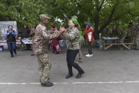 A volunteer dances with a military officer