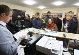 An employee of the infocentre distributes tickets to visitors