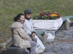 Visitors to the exhibition of flowers rest on the bench