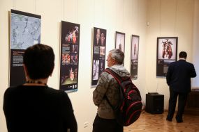 Visitors to the exhibition are looking at a photomonk with masks
