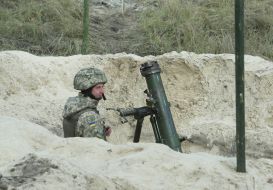 A serviceman near a mortar in a trench