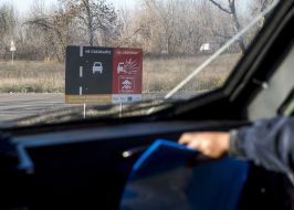 Предупредительная табличка "Не съезжать на обочину. Стоп мины" на дороге