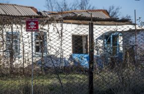 Табличка "Стоп мины" на заборе