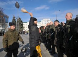 Священник окропляет святой водой военнослужащих