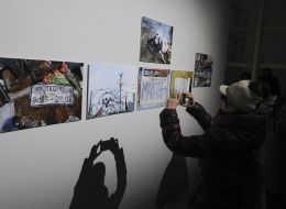 Женщина фотографирует фото исторических дней Революции достоинства