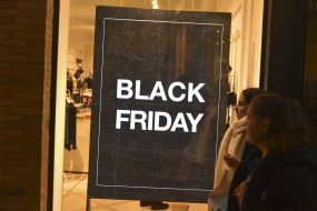 Плакат с надписью Black Friday в витрине магазина