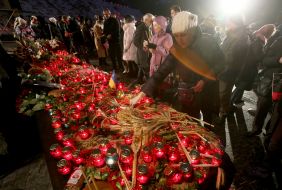 Люди ставят зажженые лампады