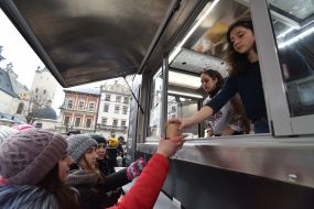 Учасниця акції пригощає перехожих супом з листя та гілок