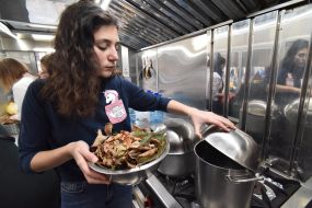 Учасниця акції готує суп з листя та гілок