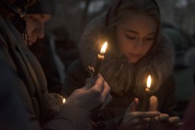Participants of the procession hold lighted candles