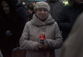 Participants of the procession hold lighted candles