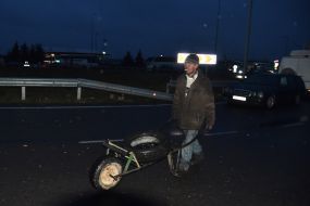 Мужчина везет автомобильную покрышку