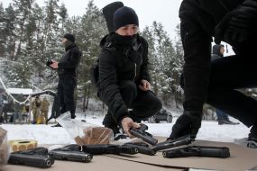 Participant of the training of the National Wives examines the gun at the training ground