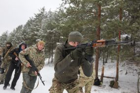 The participant of the training of the National Wives is shooting from the machine gun at the training ground