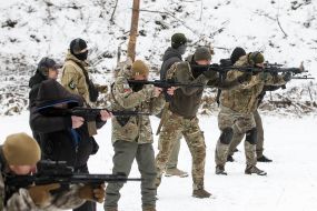 Участники подготовки Национальных дружин стреляют из автоматов на полигоне