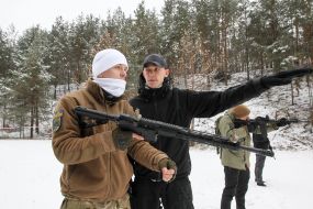 Участники подготовки Национальных дружин стреляют из автоматов на полигоне