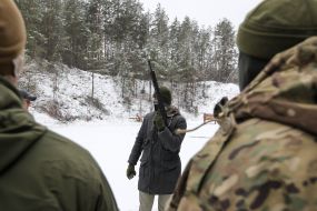 Инструктор Национальных дружин с автоматом на полигоне