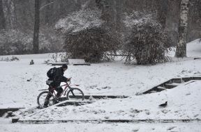 A man with a bike overcomes a snowy staircase