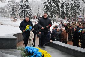 Laying flowers at the memorial sign "Heroes of Chernobyl"
