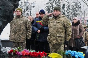 Laying flowers at the memorial sign "Heroes of Chernobyl"