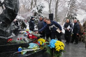 Laying flowers at the memorial sign "Heroes of Chernobyl"