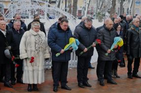 Laying flowers at the memorial sign "Heroes of Chernobyl"