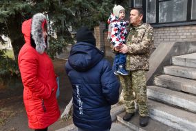 A serviceman holds a child on his hands