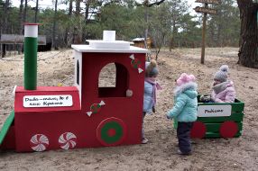 Children play around a toy train