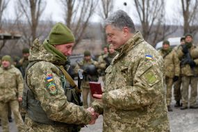 Petro Poroshenko handing the trophy to the soldier