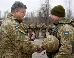 Petro Poroshenko handing the trophy to the soldier