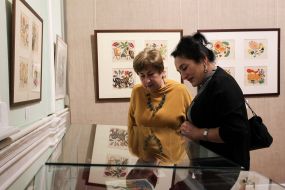 Посетительницы выставки рассматривают картины Марии Примаченко