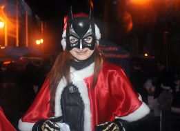 Girl in a suit of Santa Claus and a mask of Batman