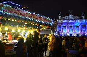 A woman with a child are photographed against the backdrop of a New Year's installation